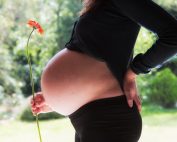 pregnant woman holding flower